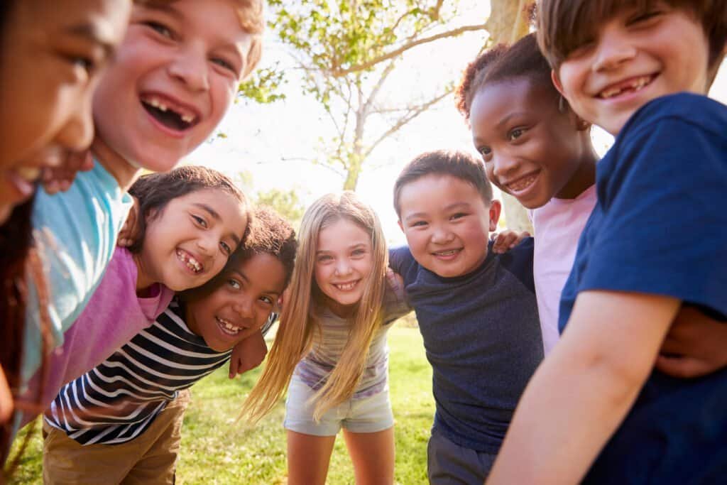 Multi ethnic,Group,Of,Schoolchildren,Laughing,And,Embracing